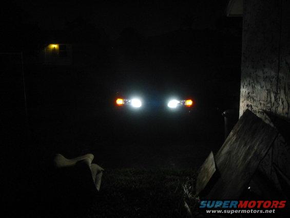 1995 Ford Thunderbird headlights and amber turn signals illuminated at night