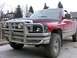 1989 Chevrolet Blazer - This red pickup truck features a large bull bar and aftermarket headlights.