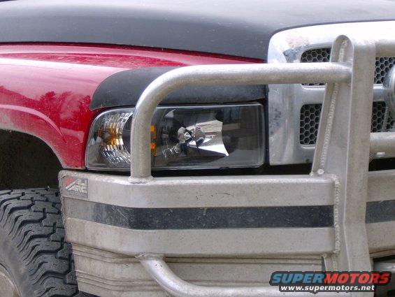 Red truck front corner with black hood, brush guard, and tire