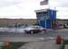 1998 Ford Crown Victoria - A two-tone 1998 Ford Crown Victoria performs a burnout in front of a drag strip tower.