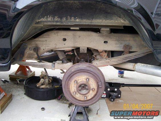 Black 1996 Ford Bronco rear axle and suspension with brake drum removed