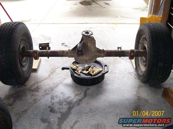 Rear axle assembly with wheels and oil drain pan