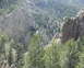 1997 Ford F-250 - A scenic view of a mountain range covered in pine trees and rock formations.
