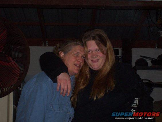 Two women posing for a photo indoors, one with her arm around the other