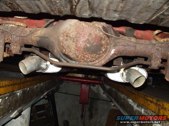 Underside view of a rusty rear differential with dual exhaust pipes
