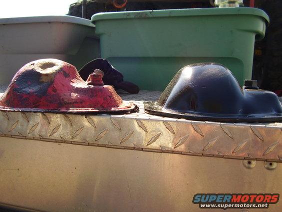 Two oil pans, one red and one black, on a metal surface
