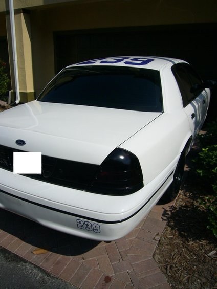 White sedan with blue numbers 239 on the rear bumper and roof