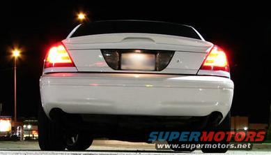 Rear view of a white 2003 Ford Crown Victoria with taillights on