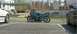 2001 BMW 3 Series - Motorcycle and BMW E36 parked in a lot with industrial buildings in the background.