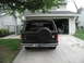 1981 Ford Bronco - The rear of a black Ford Bronco is shown parked in a driveway in front of a garage.