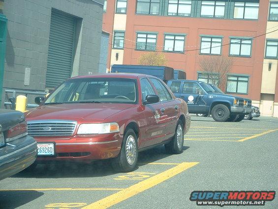 Red 2000 Ford Crown Victoria sedan parked in a lot, front quarter view. License plate 6926D
