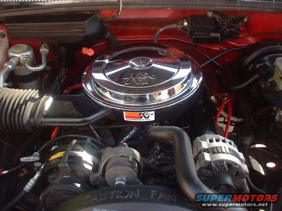 Engine bay with K&N air filter and "CAUTION FAN" text
