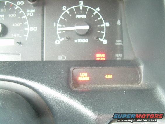 Dashboard with RPM and speedometer gauges, illuminated 'LOW RANGE' and '4X4' indicators