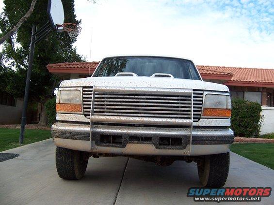 Front view of a white Ford F-Series truck, likely 1992-1997 model year, with a chrome grille and brush guard