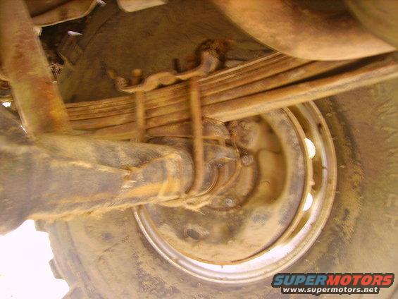 Undercarriage view of leaf springs and wheel with Supermotors.net watermark