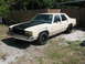 1985 Ford Crown Victoria LTD - This older model sedan has a matte black hood and black steel wheels.