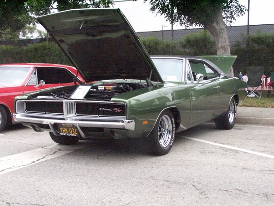 Green Dodge Charger with hood open, parked next to a red car