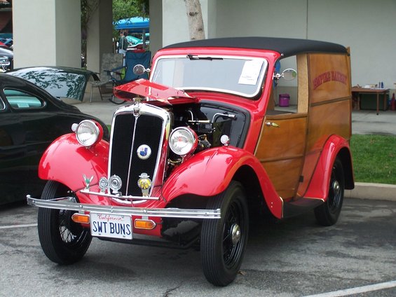Red panel van with wood siding and hood open, showing engine