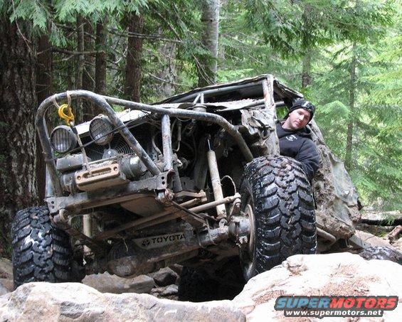 Off-road Toyota with a roll cage and large tires, man in driver's seat