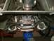 1990 Ford Mustang - Underside view of a vehicle's drivetrain and exhaust system, supported by a hydraulic jack.