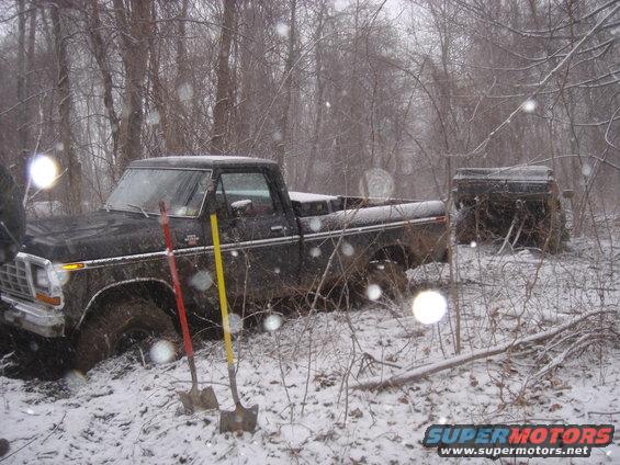 Black 1979 Ford F-250 stuck in snow, with another vehicle in the background