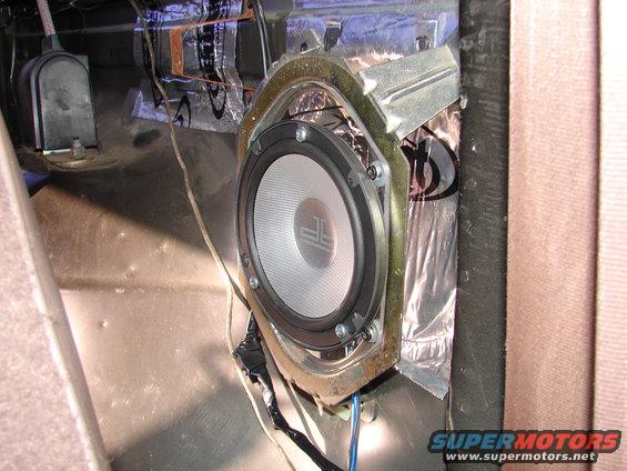 Aftermarket speaker installed in car door panel with sound deadening material