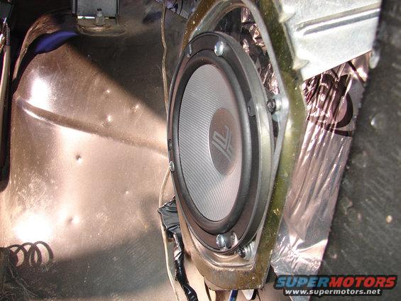 Aftermarket speaker mounted in a car door panel with sound deadening material