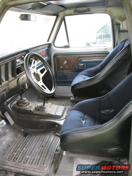 1979 Ford Bronco interior showing aftermarket bucket seats, Grant steering wheel, and floor shifters