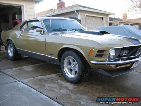 Gold 1970 Ford Mustang with hood scoop and racing stripes