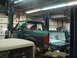 1996 Ford Bronco - Green 1996 Ford Bronco in a garage, lifted for repairs with the tailgate down.