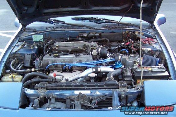 1989 Ford Probe engine bay with blue spark plug wires and aftermarket air filter