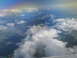 1995 Ford C-350 (Centurion Conversions) - View from an airplane window shows clouds and a distant rainbow over a mountainous landscape.
