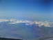 1995 Ford C-350 (Centurion Conversions) - An aerial perspective captures the grandeur of snow-covered mountain ranges beneath a vast expanse of blue sky.