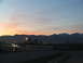 1995 Ford C-350 (Centurion Conversions) - A car drives across a bridge at sunset, with a mountain range visible in the distance.