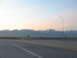1995 Ford C-350 (Centurion Conversions) - Driving on a highway with a mountain range visible at sunset.