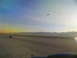 1995 Ford C-350 (Centurion Conversions) - An airport scene at sunrise with mountains on the horizon and an airplane in the sky.