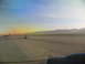 1995 Ford C-350 (Centurion Conversions) - View of an airport tarmac during sunrise, with mountains on the horizon and airplanes visible.