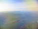 1995 Ford C-350 (Centurion Conversions) - An aerial view shows a valley with mountains, a lake, and scattered development under a hazy sky.
