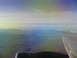 1995 Ford C-350 (Centurion Conversions) - View from an airplane window shows a wing and engine against a backdrop of a valley and distant mountains.