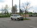 1995 Ford C-350 (Centurion Conversions) - White 1995 Ford C-350 (Centurion Conversions) SUV parked in a lot with trees and fencing in the background.