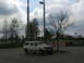 1995 Ford C-350 (Centurion Conversions) - A white SUV is parked in an empty lot under a cloudy sky.