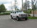 1995 Ford C-350 (Centurion Conversions) - A white Ford SUV is parked in a lot on a cloudy day.