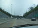 1995 Ford C-350 (Centurion Conversions) - Driving on a highway with multiple lanes and traffic under an overcast sky.