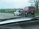 1995 Ford C-350 (Centurion Conversions) - A red Ford Expedition is transported on a trailer, towed by a white SUV on the highway.