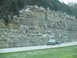 1995 Ford C-350 (Centurion Conversions) - A pickup truck travels down a highway beside a large, layered rock formation.