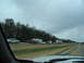1995 Ford C-350 (Centurion Conversions) - A long line of vehicles are stopped on the highway under a cloudy sky.