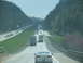1995 Ford C-350 (Centurion Conversions) - Vehicles travel on a multi-lane highway surrounded by hills and trees.