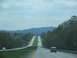 1995 Ford C-350 (Centurion Conversions) - A highway stretches into the distance with vehicles traveling in both directions under a cloudy sky.