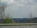 1995 Ford C-350 (Centurion Conversions) - A view of trees and hills from a moving vehicle on a cloudy day.