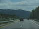 1995 Ford C-350 (Centurion Conversions) - Driving on a highway with other vehicles and a mountainous landscape in the background.